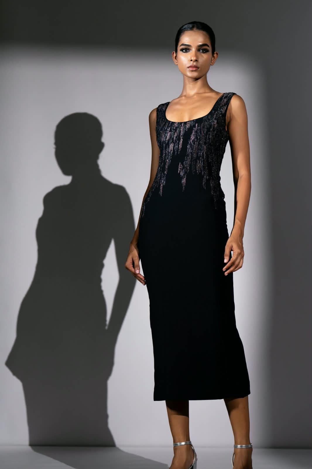 The Nocturne dress, a sleeveless black column to mid-calf with a scoop neckline and a drift of beadwork across the bodice.